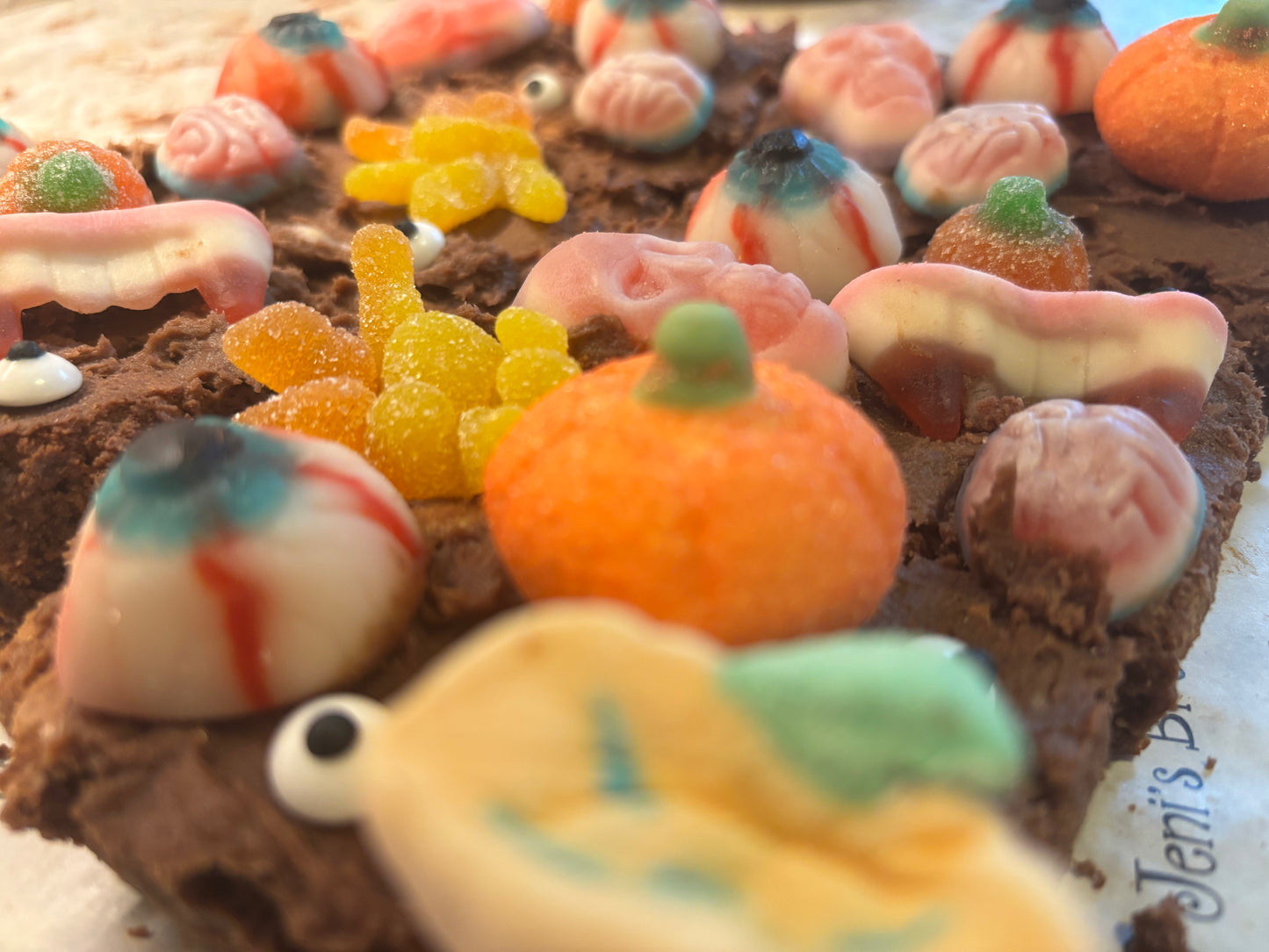 Close-up of a chocolate cake with Halloween-themed candy decorations.